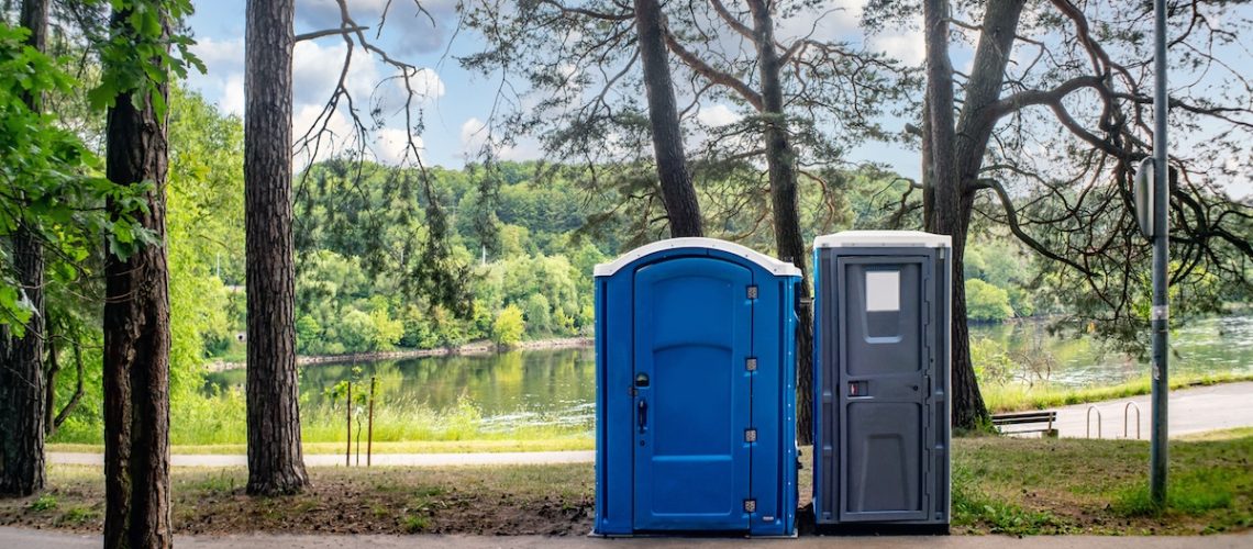 Two portable toilets in a park