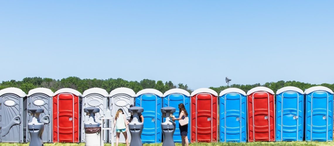 Row of colorful mobility lavatory and washbasin, hygiene facility for people at outdoor event. Public temporary restroom at a park, attendees using amenity during festival, convenience and sanitation