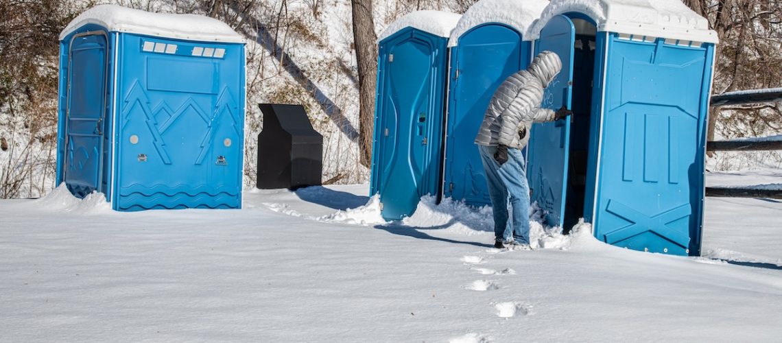 Man investigating a portable toilet on cold winter day in central Virginia.